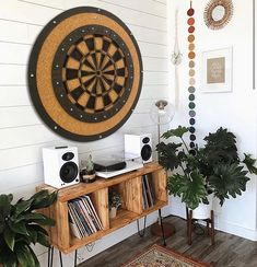 a living room filled with furniture next to a wall mounted dart board on the wall