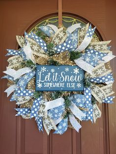 a blue and white wreath that says let it snow somewhere else