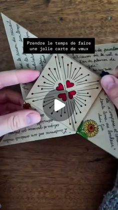 someone is holding an origami piece with hearts on it and the words in french are