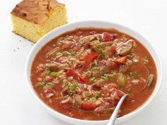 a white bowl filled with soup next to a piece of bread