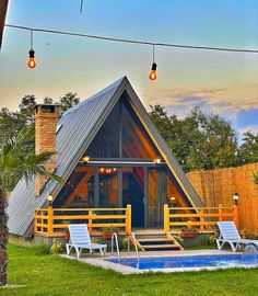 a - frame cabin with pool and hot tub in the backyard at sunset or dawn