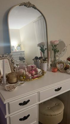 a white dresser topped with a mirror and lots of drawers