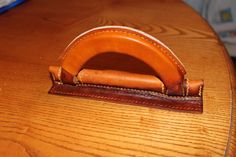 a wooden table topped with a brown leather desk top and a pen holder on top of it