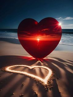 a heart shaped object sitting on top of a sandy beach