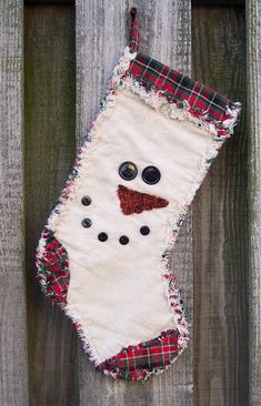 a christmas stocking hanging on a wooden fence with eyes and nose patched in