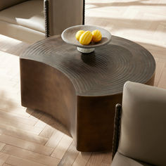 a bowl with some fruit on top of it sitting on a table in a living room