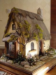 an image of a small house made out of fake grass and rocks with ivy growing on the roof