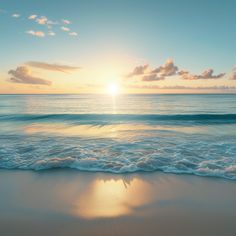 the sun is setting over the ocean with waves coming in to shore and blue sky