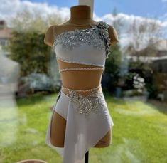 a mannequin dressed in white with silver sequins on it's chest