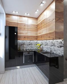 a modern kitchen with wood paneling on the walls and black counter tops, along with stainless steel appliances