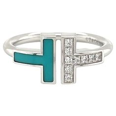 From Tiffany & Co. This diamond and turquoise ring is from Tiffany T Collection, it is crafted from 18k white gold featuring a double T style at the front with an open space in the center. One T is decorated with diamonds and the other T has turquoise inlay. The 2mm thick wire band is in polished finish. The ring is signed by the designer with the gold content. Brand: Tiffany & Co. Hallmark: T&Co. Au750 Italy Diamonds: 0.07ct Gemstone: turquoise Ring Size: 6 Weight: 4.5 grams Tiffany And Co Diamond, Tiffany T, Wire Ring, Wire Rings, Tiffany And Co, Tiffany & Co., Diamond White, Turquoise Ring, Band Rings