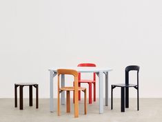 three chairs and a table in different colors