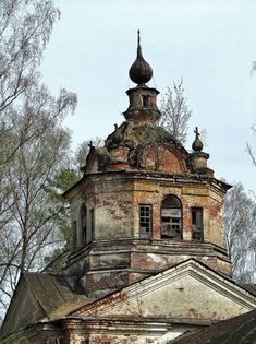 an old brick building with a steeple and weather vane on it's roof