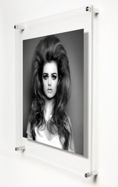 a black and white photo of a woman with long hair in a frame on the wall