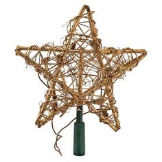 a star made out of branches on top of a green pole next to a white wall