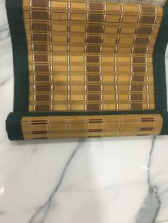 a brown and green purse sitting on top of a marble counter