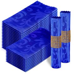 blue paper napkins with gold embellishments and matching napkins are stacked on top of each other