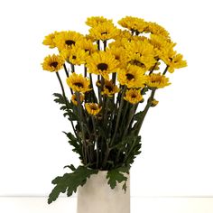 a white vase filled with yellow flowers on top of a table