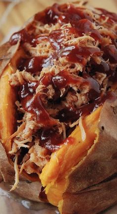 an open sandwich with meat and ketchup sitting on top of a wooden table