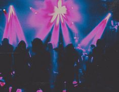 a group of people standing on top of a stage with lights in the dark behind them