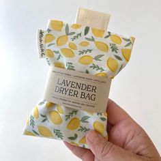 a hand holding a bar of soap with lemons printed on it and the label says lavender dryer bag