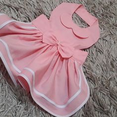 a pink dress laying on top of a carpet