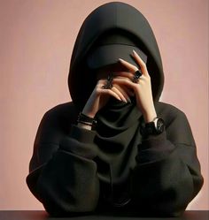 a woman with her hands on her face, wearing a black hoodie and matching rings