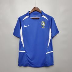 a blue shirt hanging on a hanger with a white and yellow soccer jersey underneath it