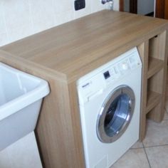 a washer and dryer sitting next to each other in a room with tile flooring