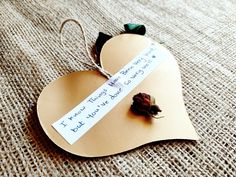 a paper heart with a rose attached to it and a note pinned to the side