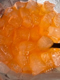 an orange juice in a blender with ice cubes