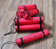 four red dynamites sitting on top of a wooden floor