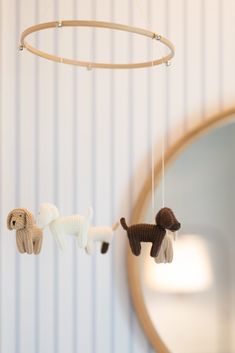 two stuffed animals are hanging from a wooden hoop on the wall next to a mirror