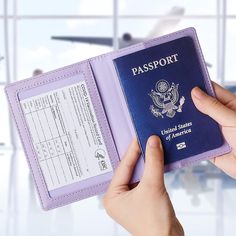 a person holding a purple passport in front of an airplane