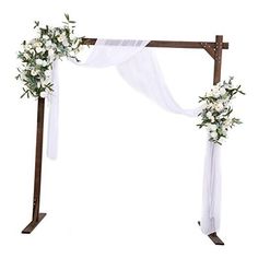 a wedding arch decorated with white flowers and greenery