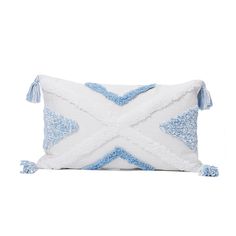 a blue and white pillow with tassels on the edges, sitting against a white background