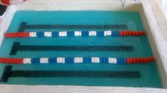 an olympic swimming pool with red, white and blue lanes in the water next to a life preserver