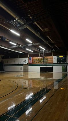 an empty gym with hard wood floors and lights