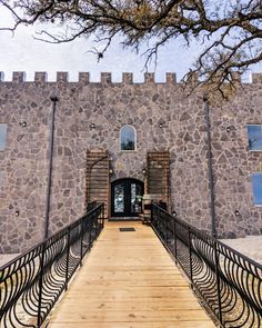 a large stone building with a wooden walkway leading up to it's entrance door