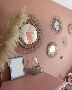 a room with pink walls and mirrors on the wall, including one mirror that is gold