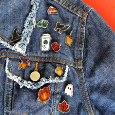 the back of a jean jacket with various pins and patches on it's lap