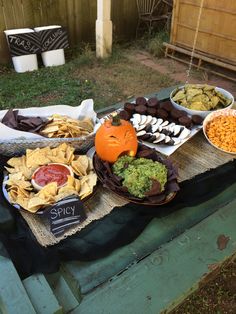 a table filled with different types of food on it's sides, including chips and dips