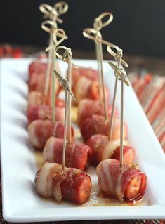 bacon wrapped in toothpicks on a white plate