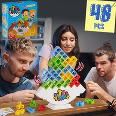 three people are playing with an interactive game on the table while another person looks at it