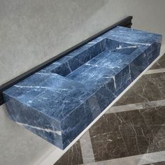 a blue marble bench sitting on top of a tiled floor