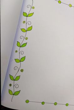 an open book with green leaves on it