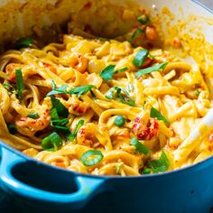 a blue pot filled with pasta and vegetables