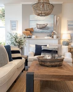 a living room filled with furniture and a chandelier hanging from the ceiling over a fire place