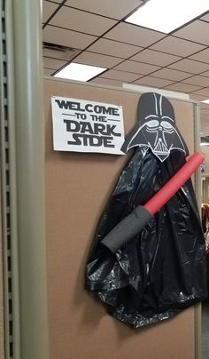 a darth vader costume is hanging on the wall in an office cubicle