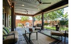 an outdoor living area with couches and tables